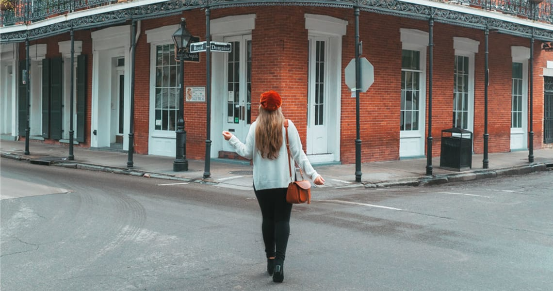 Woman Standing in an Intersection in French Quarter New Orleans | Reve Realtors