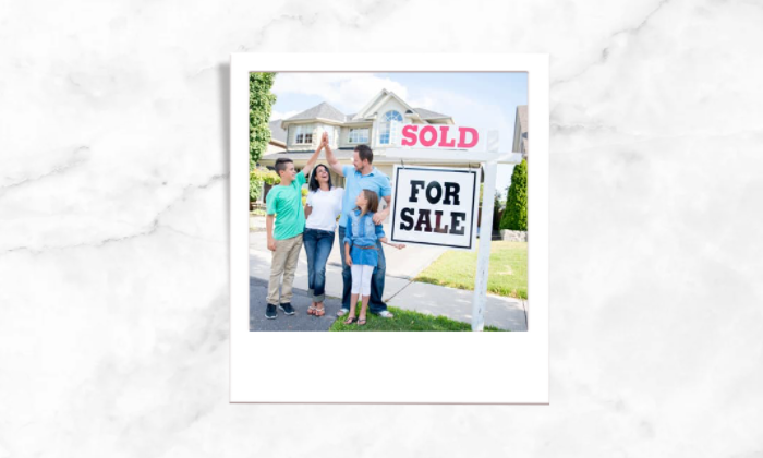 Photo of a happy family in front of a for sale house