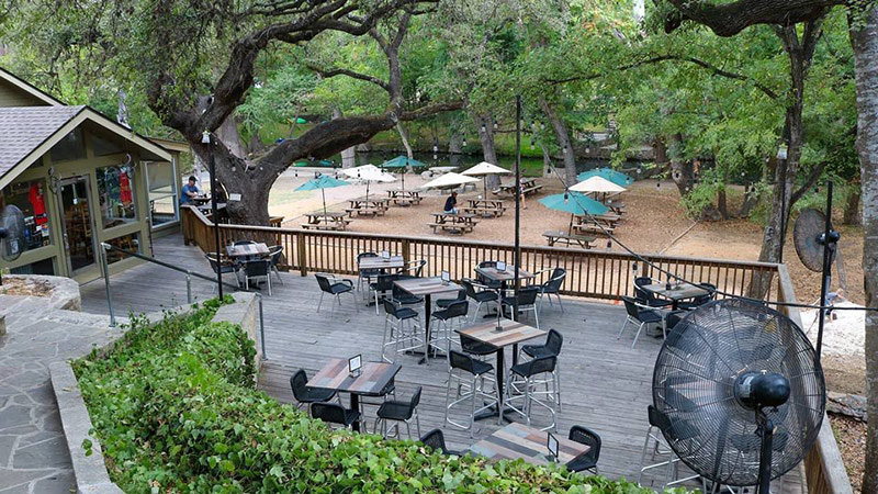 Chill's on the Creek patio dining under live oak trees.