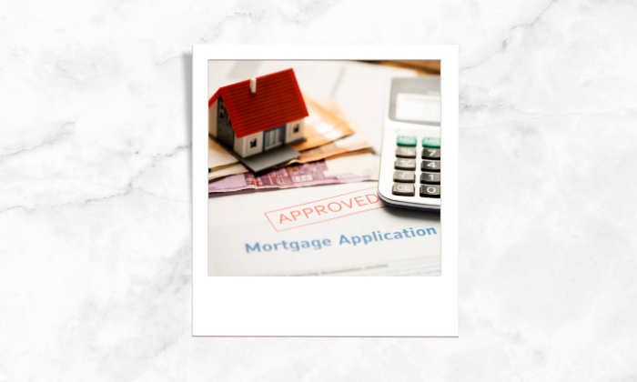 A photo of a approved mortgage application form, money, calculator and a house block