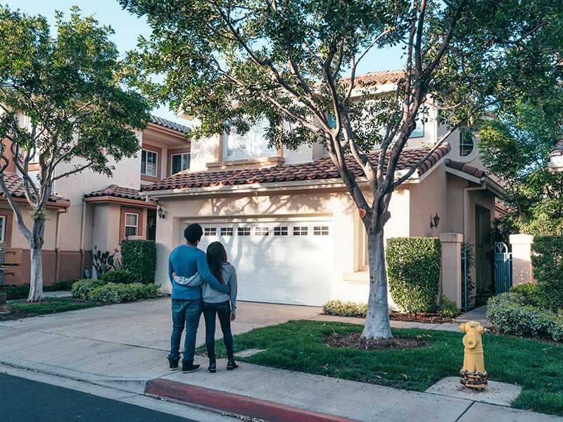 Image of a couple standing in front of their new home