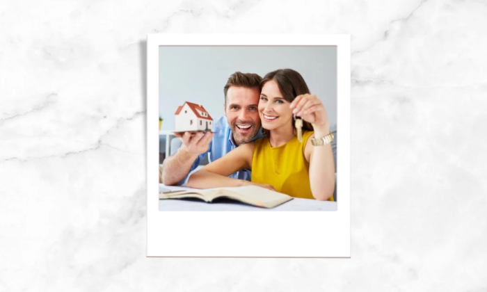 Photo of a couple holding a house model and a house key