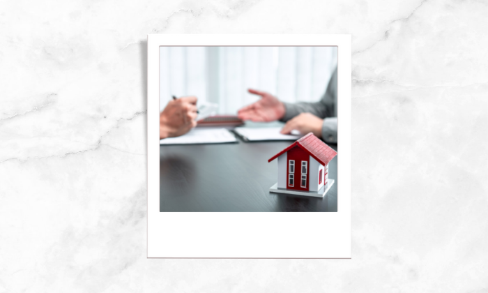 Photo of two people discussing behind a house model
