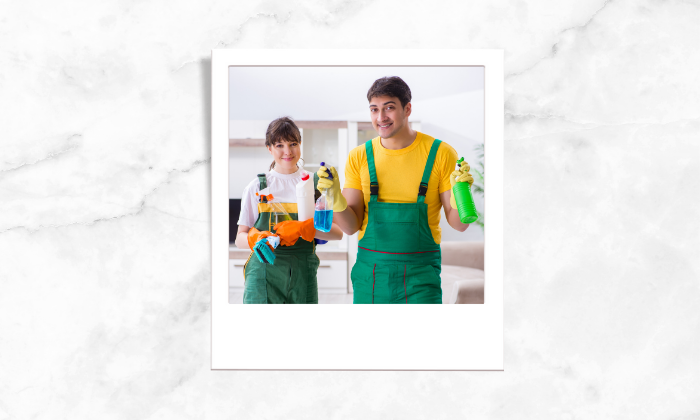 Photo of two people suit up with cleaning tools 