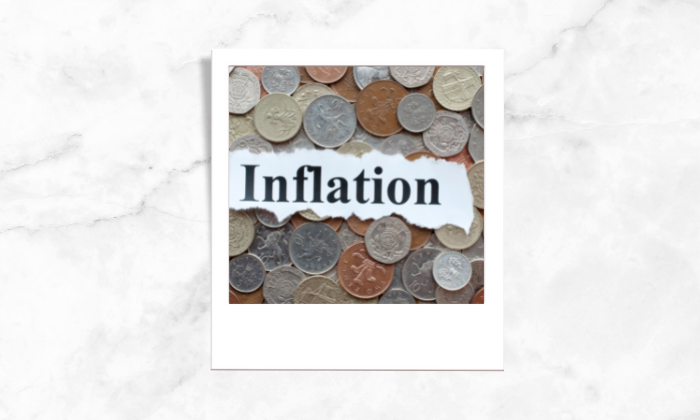 Photo of a text written inflation surrounded by coins