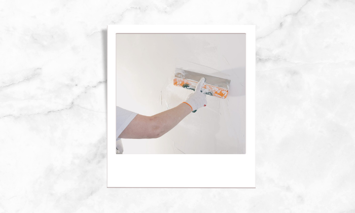 Photo of a person painting the walls