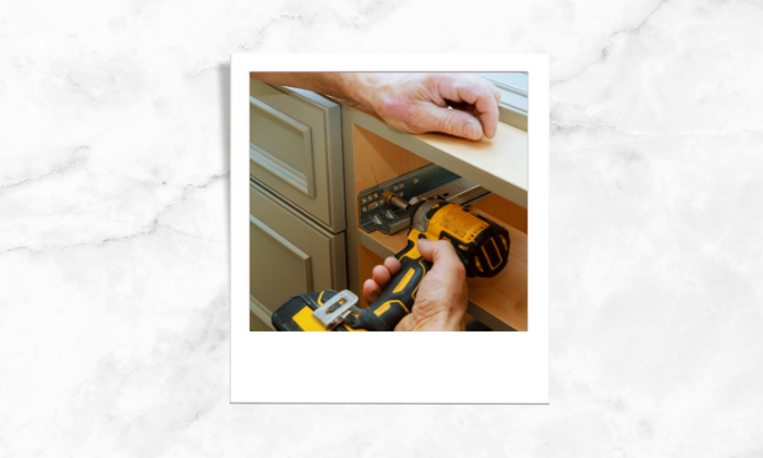 Photo of a person fixing the kitchen cabinets