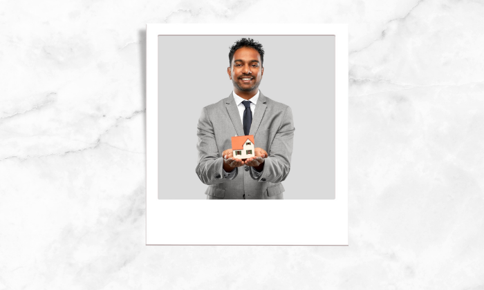 Photo of a realtor holding a model of a house