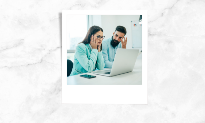 Photo of two people discussing in front of a laptop