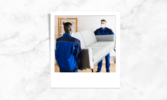 Photo of two workers setting up a sofa during pandemic