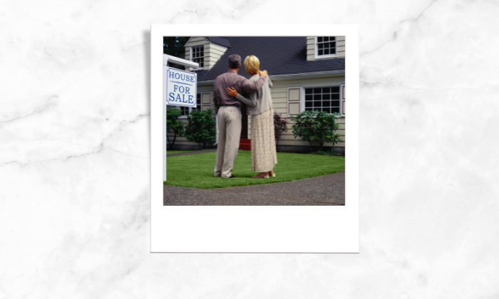 Photo of a couple looking over a for sale house