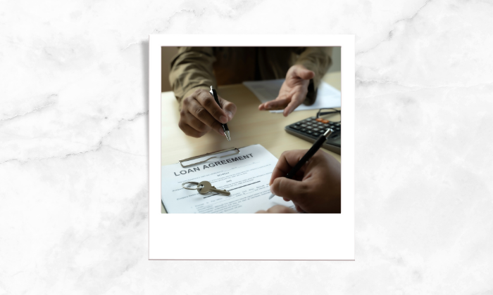 Photo of a person signing a loan agreement form