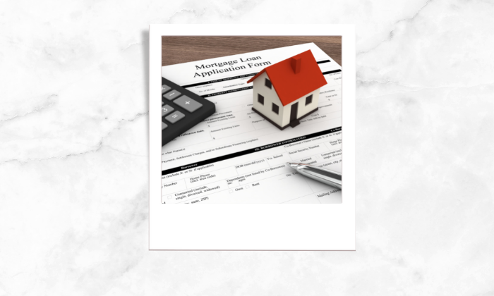 Photo of a mortgage loan application form with a toy house, calculator and a pen above