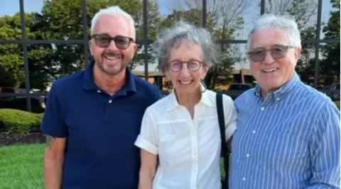 Group of three happy clients in front of office building