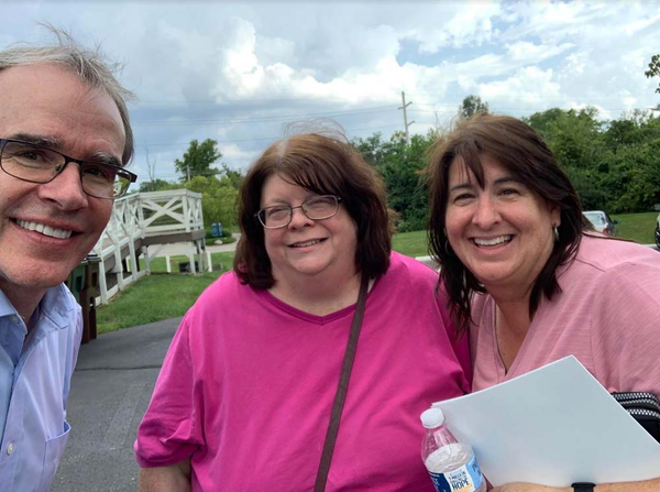 Happy clients smiling next to David Campbell outside.