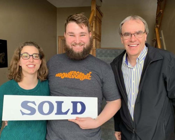 Happy Couple holding SOLD sign next to David Campbell.