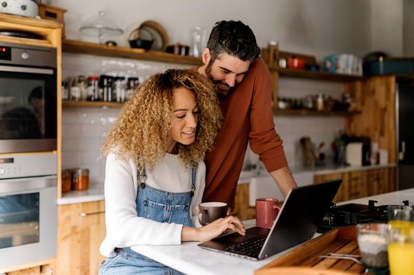 couple-looking-at-laptop-in-kitchen-2023-03-23-22-36-48-utc (1)