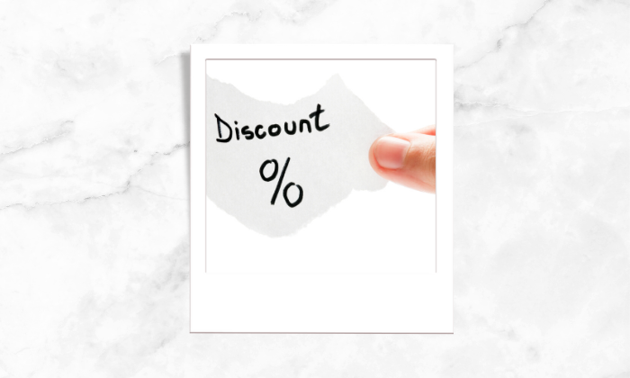 A photo of a person holding a piece of a paper with discount