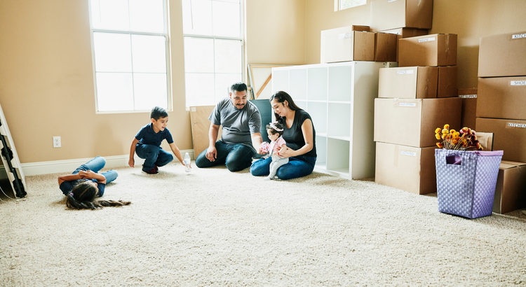 Family moving into new home in room full of boxes