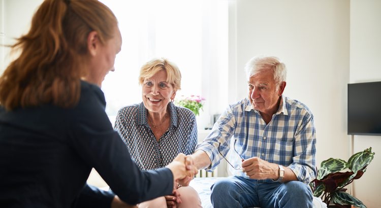 Two home owners working with a real estate agent to sell their home