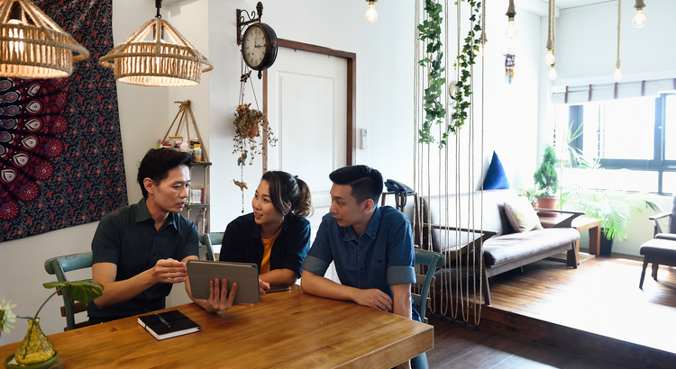 Home sellers working with a real estate agent while sitting inside of home
