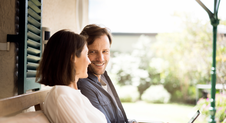 Two homeowners sitting on porch outside
