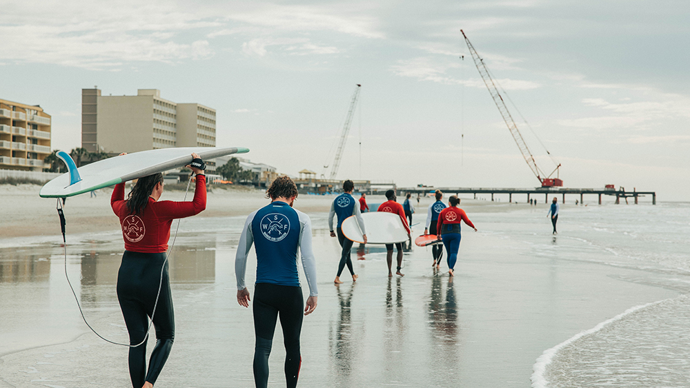 surfers on folly beach by andrew shelley