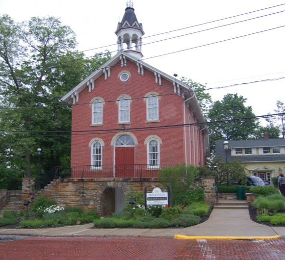 Brecksville's old town hall a two story colonial building, made of red bricks, white windows and trims, red door and with a white and grey cupola on top of the roof located near homes for sale in Brecksville Ohio