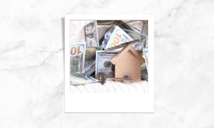 A photo of a house block and house key surrounded by money