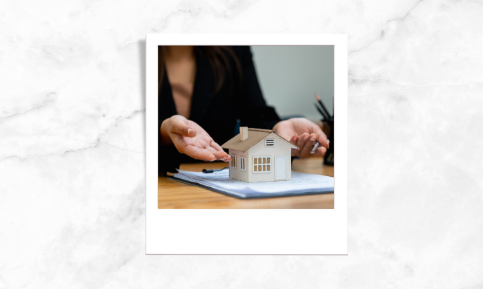 A photo of an individual pointing to a house block