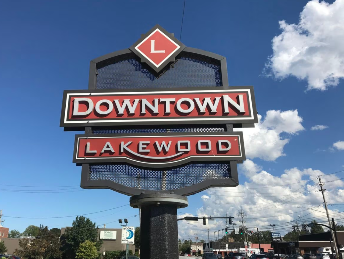 bottom view of an iron grey and red street sign that reads "Downtown Lakewood" located near homes for sale in Lakewood Ohio