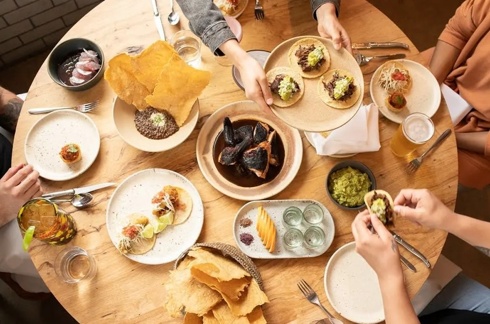 top down image of people sharing plates of food at one of the best Austin restaurants