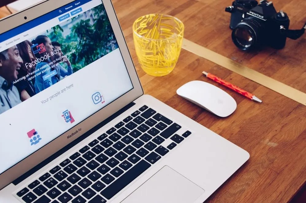 laptop on desk showing facebook