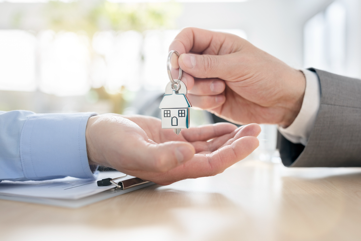 Real estate agent handing over the keys to a newly owned condominium