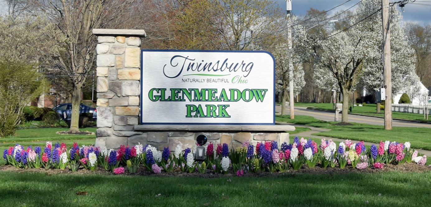 Stone monument sign with a whiteboard reading "Twinsburg naturally beautiful Ohio Glenmeadow Park, located near homes for sale in Twinsburg Ohio