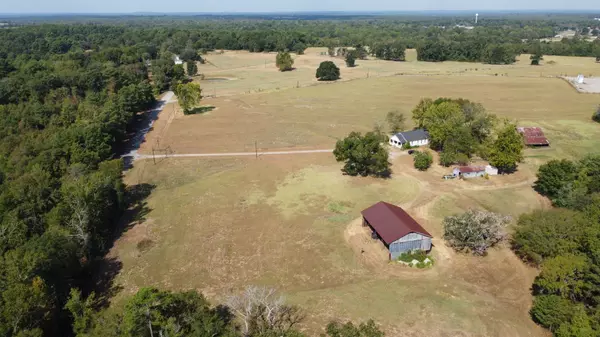 aerial view of pastures barns and home on ranch for sale near arp texas