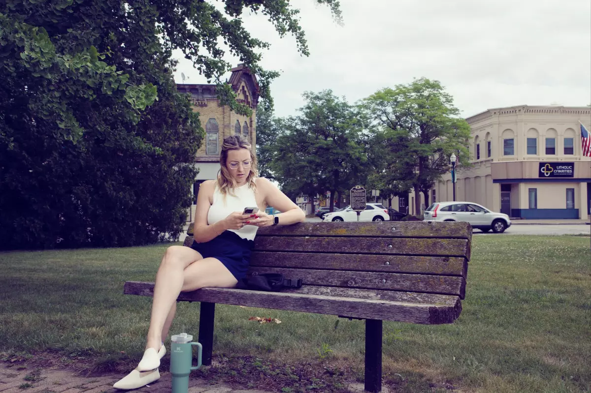 Kelly Northlee sitting outside in a bench chair