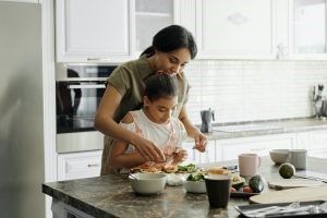 Mother and daughter cooking in their new kitchen. 