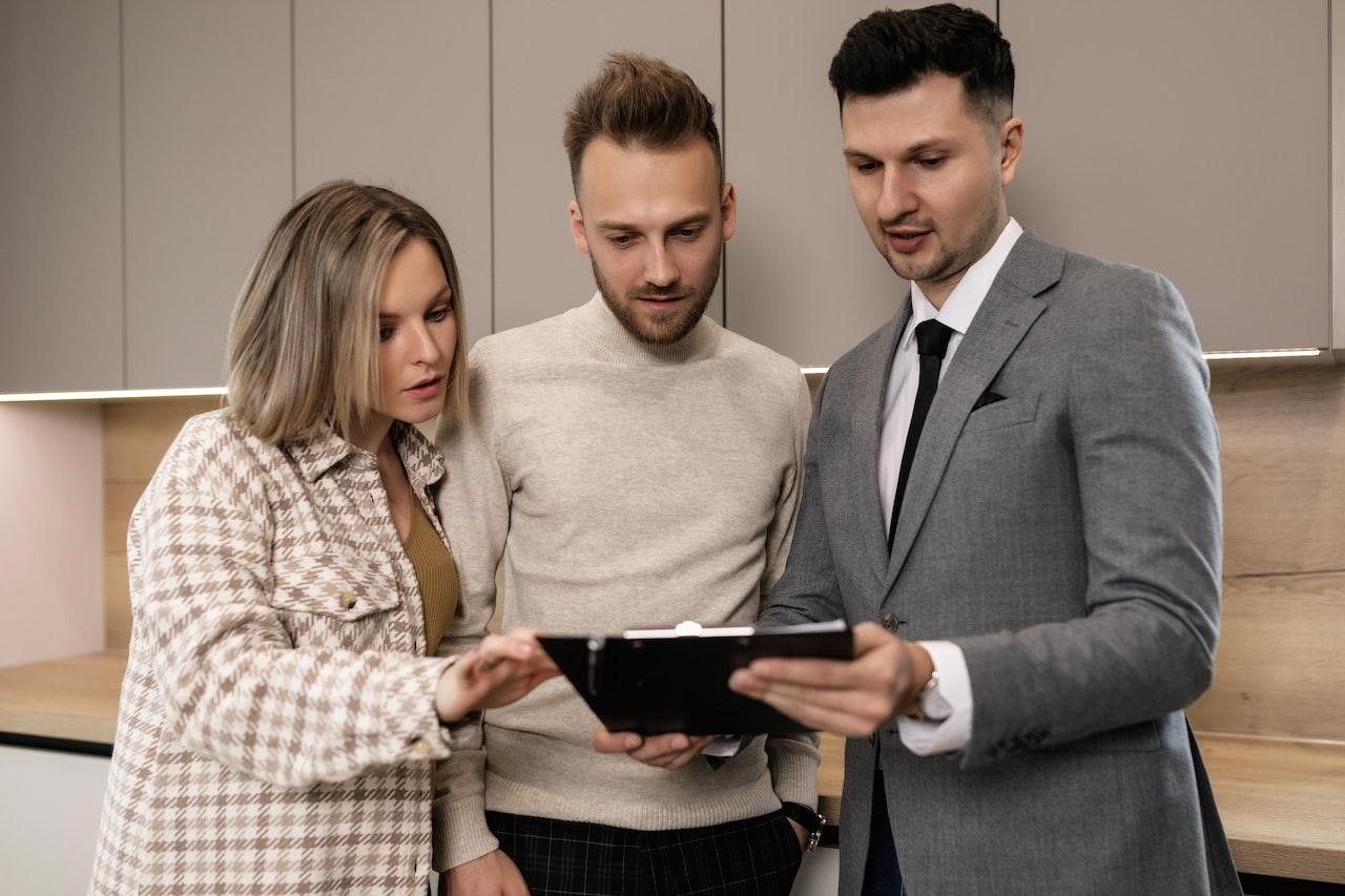 Couple negotiating with an agent when buying a home. 