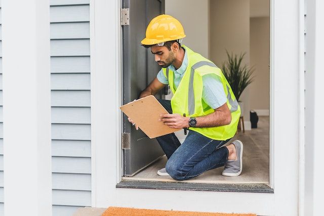Home inspector taking notes while inspecting a door
