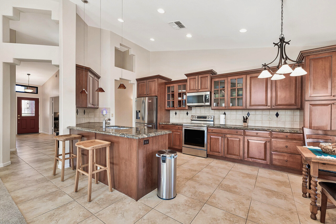 A modern kitchen featuring custom cabinets, granite countertops, and stainless steel appliances. The open design is bright and inviting, with ample counter space and sleek finishes, perfect for cooking and entertaining.