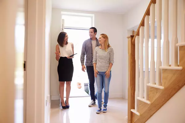 realtor-showing-young-couple-around-house