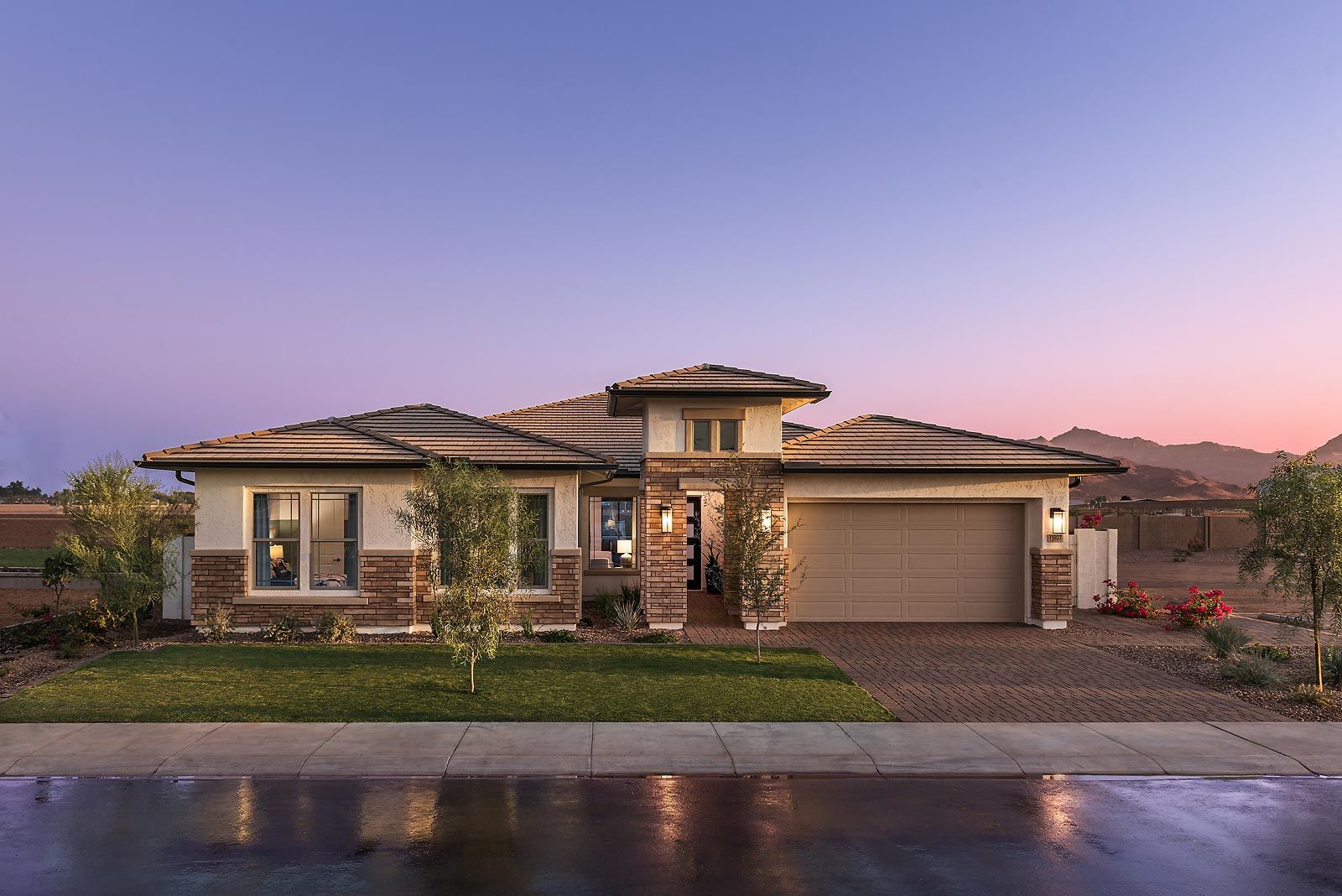 Beautiful new construction home with modern white exterior, brick accents, and large windows at sunset – highlights why having a real estate agent is essential to negotiate upgrades, pricing, and ensure you're protected throughout the building process.