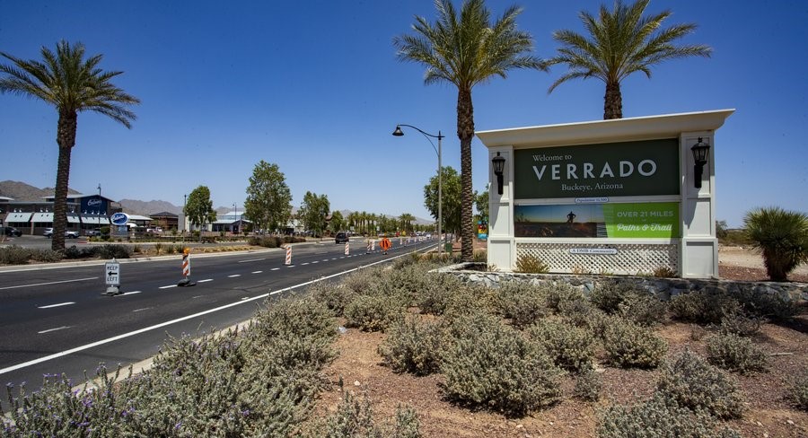 Entrance to Verrado community in Buckeye, Arizona, showcasing scenic palm-lined streets, community amenities, and over 21 miles of trails – highlighting the attractive lifestyle of this master-planned neighborhood.