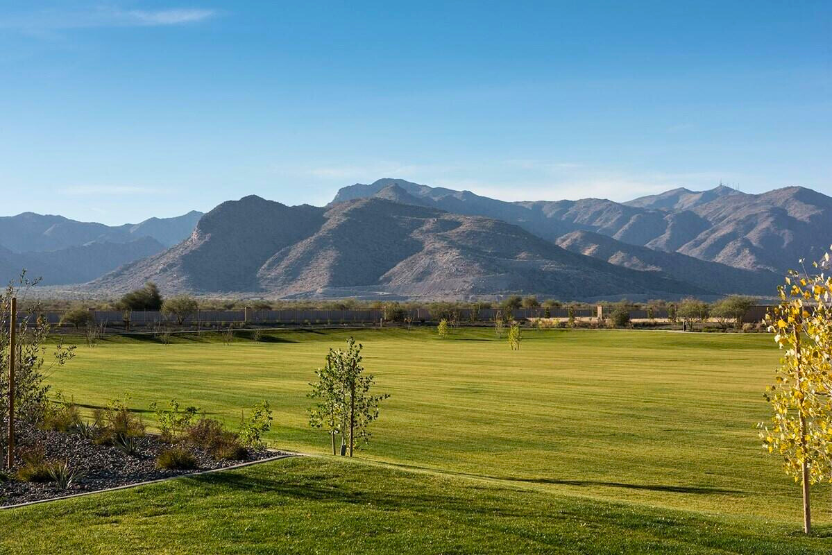 Stunning view of mountain ranges near new construction homes in the Sentiero at Windrose community, Waddell, Arizona, showcasing open green spaces and picturesque landscapes perfect for family living and luxury homes by David Weekley Homes.