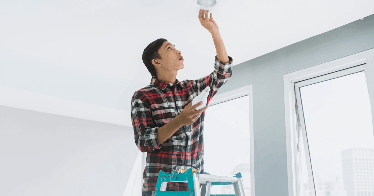 Side view of man painting exterior of home