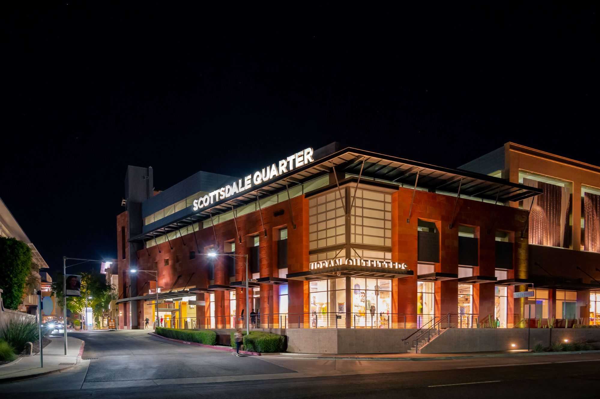 Nighttime view of Scottsdale Quarter, showcasing its ongoing significant redevelopment with exciting new openings and re-openings. Recent highlights include the return of the popular Etta restaurant, now offering a wood-fired menu and live DJ performances, alongside the reopening of Sephora. New additions to the retail lineup include Ariat, Aroma 360, Creations Boutique, Hammer Made, Jenni Kayne, Jeni’s Splendid Ice Creams, Pandora, and Reformation. Anticipated future openings include Fashionphile, Lilly Pulitzer, Rails, Solidcore, Sweet Paris Creperie, Williams Sonoma, and Swarovski in 2025. This redevelopment reinforces Scottsdale Quarter's status as a premier destination for shopping, dining, and entertainment, blending innovation, style, and community.