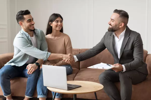 couple-buying-new-apartment-shaking-hands-with-re-2023-11-27-04-57-03-utc