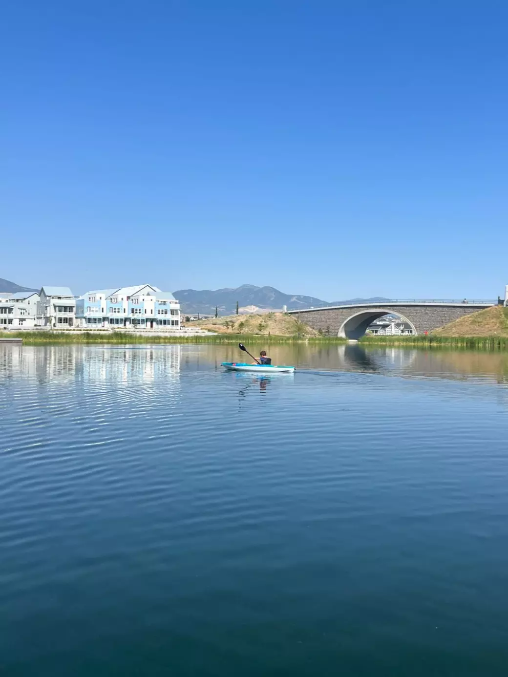 Oquirrh Lake on a sunny day with a Paddle boarder