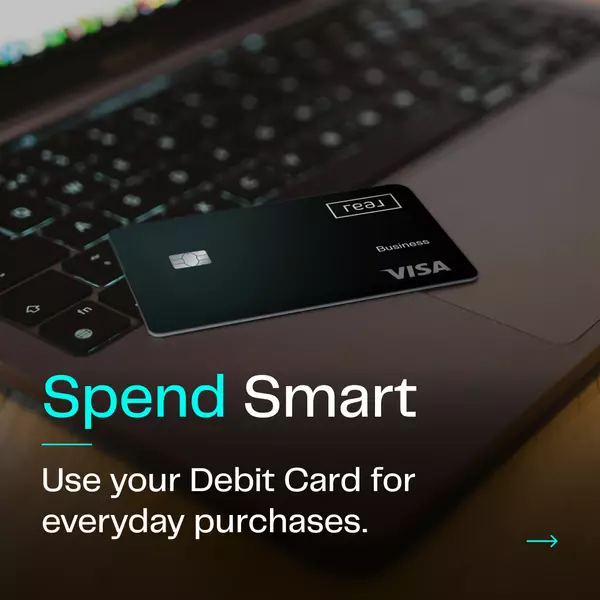 Real Wallet Business Debit Card on laptop, highlighting convenience of using the Real Wallet debit card for everyday purchases. 'Spend Smart' with Real Broker's innovative debit card, featuring rewards and financial perks for agents.